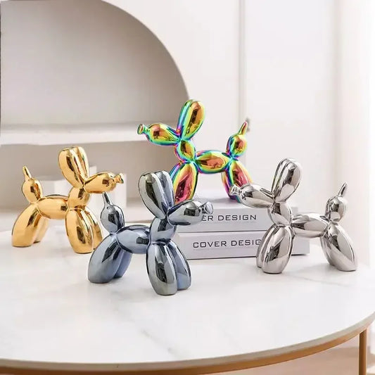Four metallic dog sculptures in different colors on a white surface.