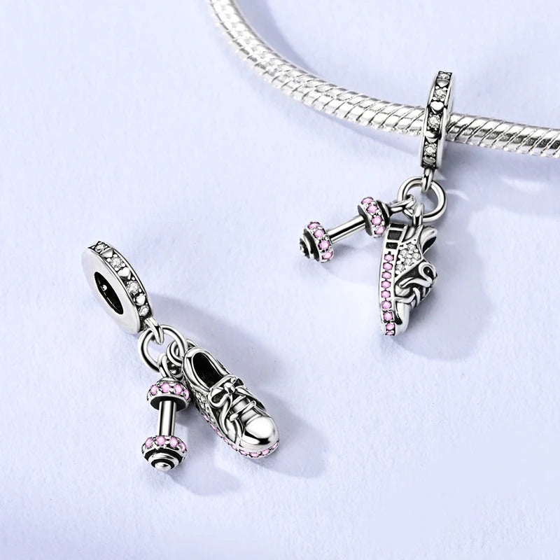 Two silver charms sneaker and dumbbell fitness charm on a white background. pandora style