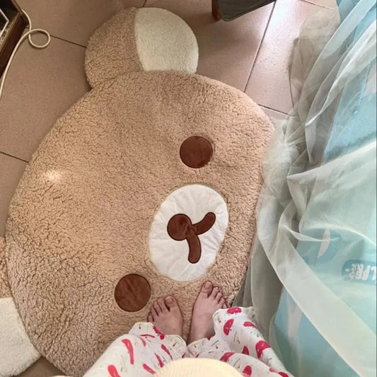Round bear-shaped rug on a tiled floor with a person wearing pajamas partially visible.