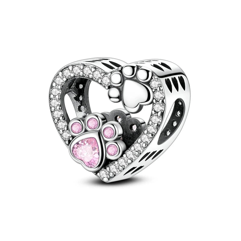 Heart-shaped charm with paw prints and a pink gem on a white background. pandora style