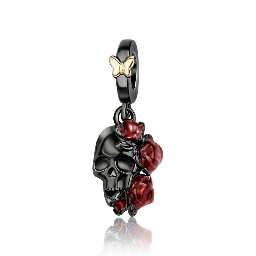 Pendant with black skull design, red roses, and gold butterfly on a white background. pandora style charm pendant. gothic, halloween