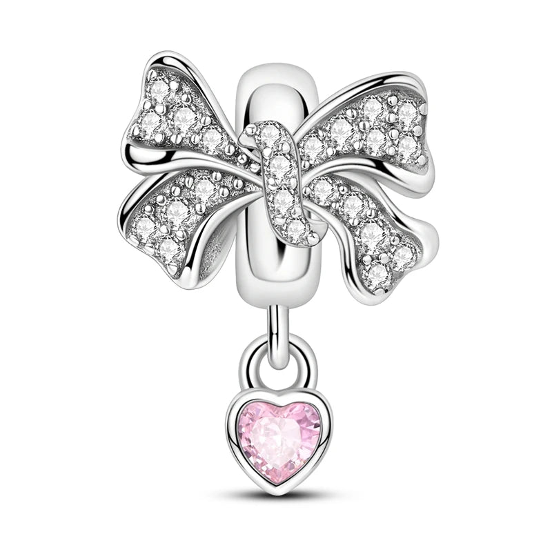 Silver bow charm with a pink heart pendant on a white background