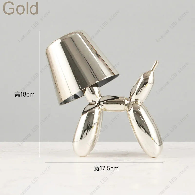 Gold-colored balloon dog sculpture with dimensions on a gray background