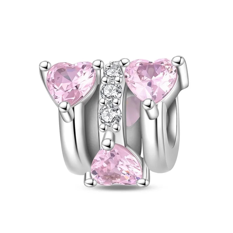 Silver charm with pink heart-shaped stones on a white background