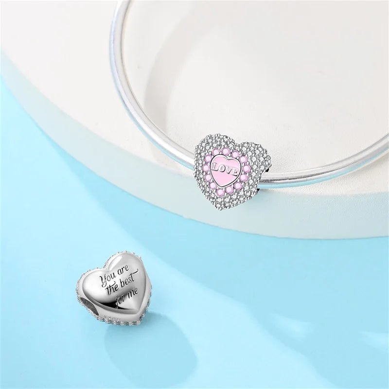 Heart-shaped silver and pink charms on a light blue background. pandora style