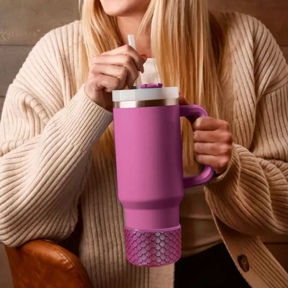 Stanley Person holding a pink travel mug with a straw, wearing a beige sweater.