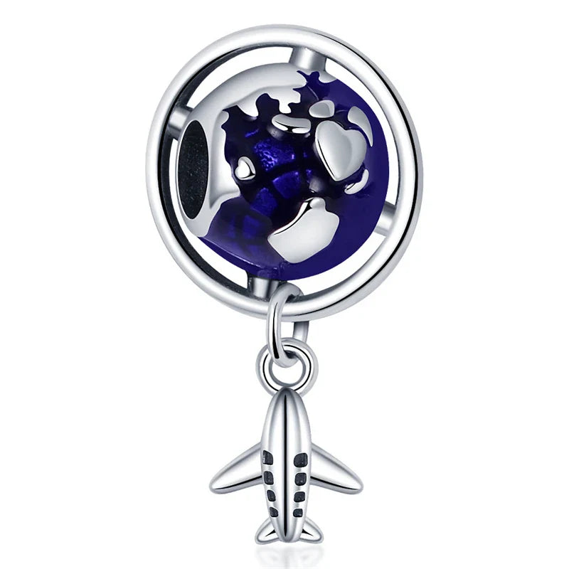 Silver charm with a globe and airplane on a white background