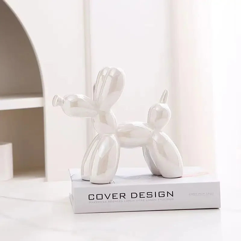 White balloon dog sculpture on a book with a white background