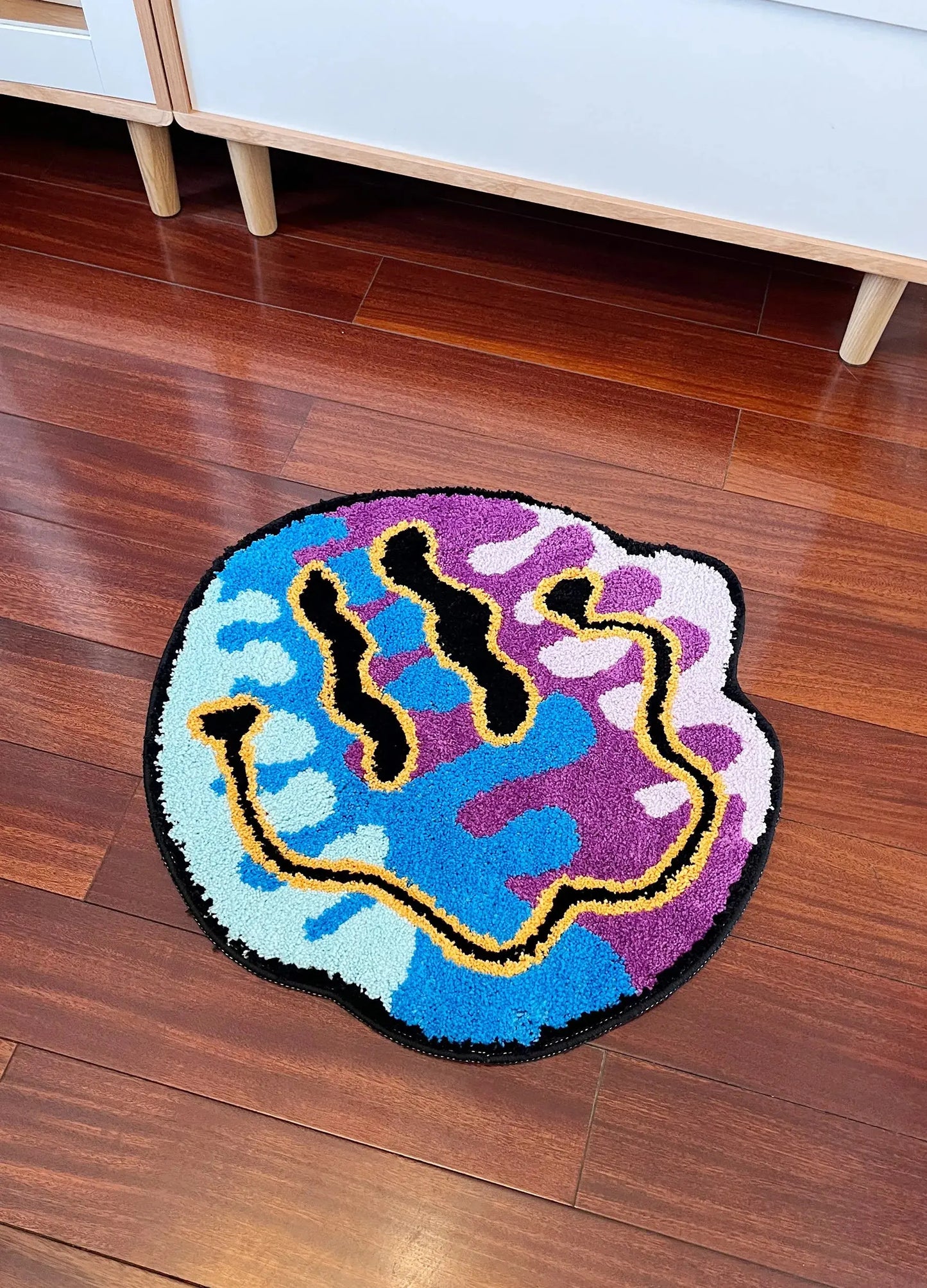 Colorful hand-shaped rug on a wooden floor