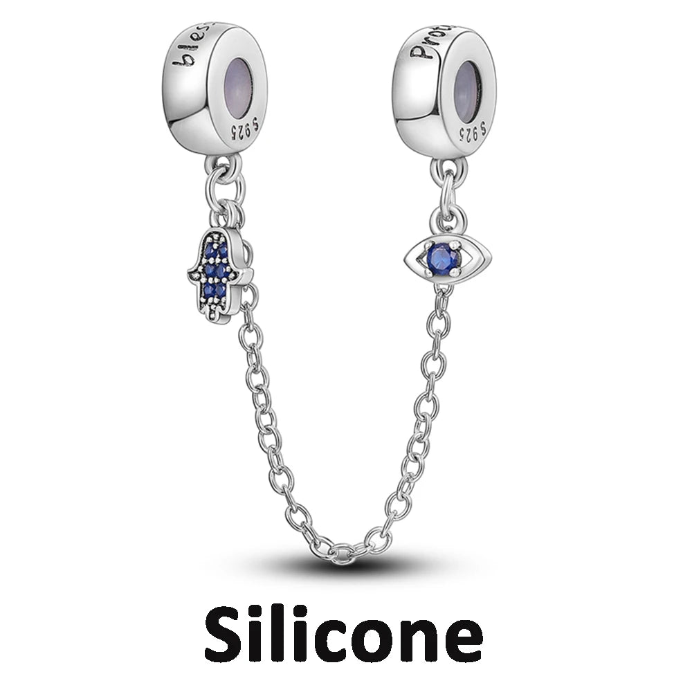 Two silver charms with blue stones on a white background, labeled 'Silicone'.