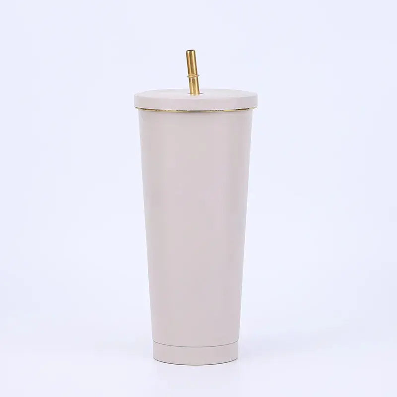 Beige tumbler with a gold straw on a white background