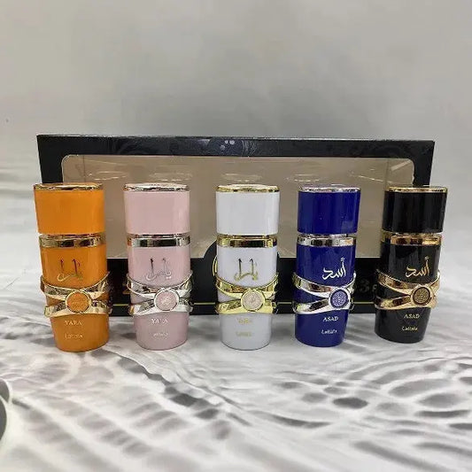 Five perfume bottles of different colors and designs on a textured surface with a neutral background.