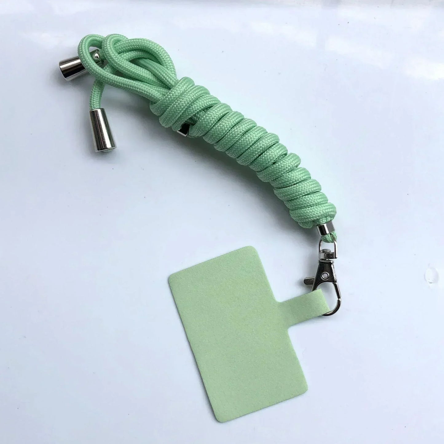 Light green paracord lanyard with metal clip on a white background
