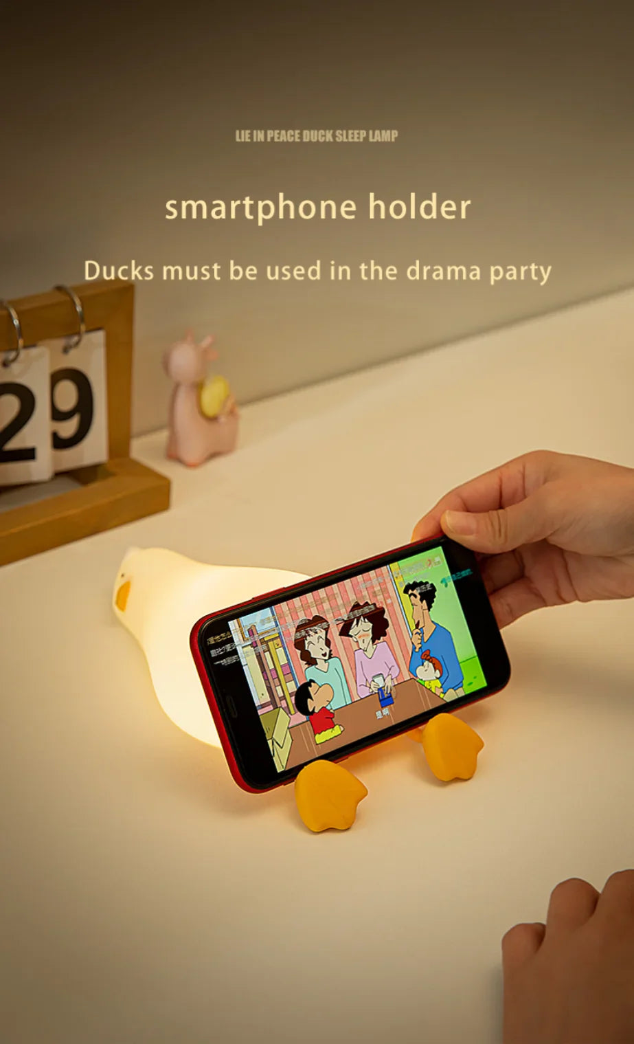 Smartphone holder shaped like a duck with a phone on a light surface.