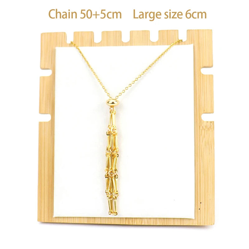 Gold necklace with tassel on a wooden display stand