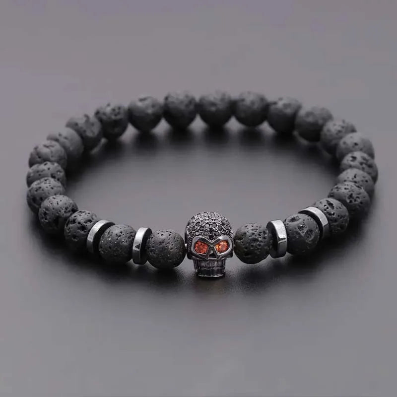 Lava stone bracelet with a skull charm on a gray background