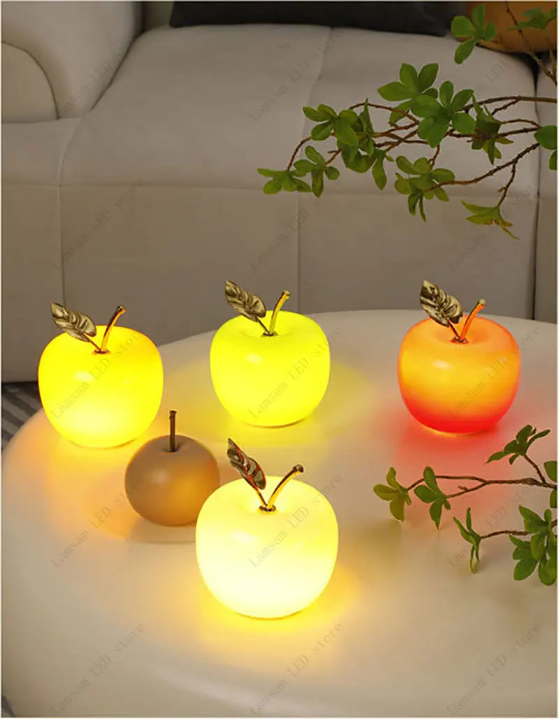Glowing apple-shaped lamps on a table with a blurred background