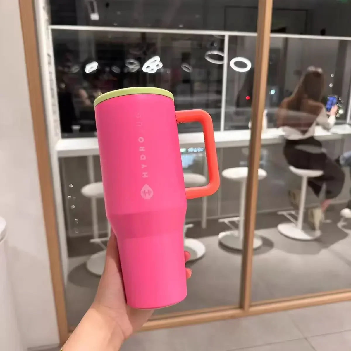 Bright pink HydroJug Gobelet 40OZ Voyageur Thermos with neon green lid and orange handle, ideal for bold hydration on the go.