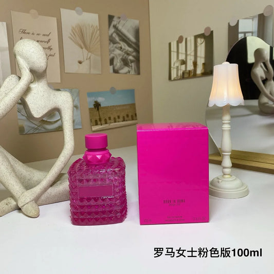 Valentino Pink perfume bottle and box on a table with decorative items in the background