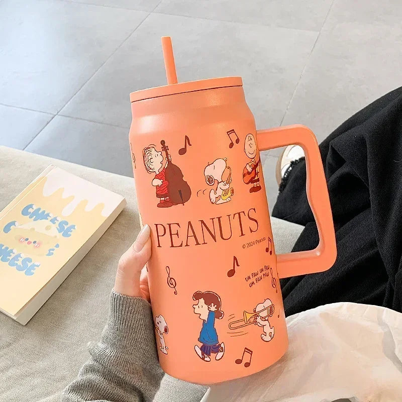 Snoopy Orange tumbler with cartoon characters and 'Peanuts' branding held by a person.