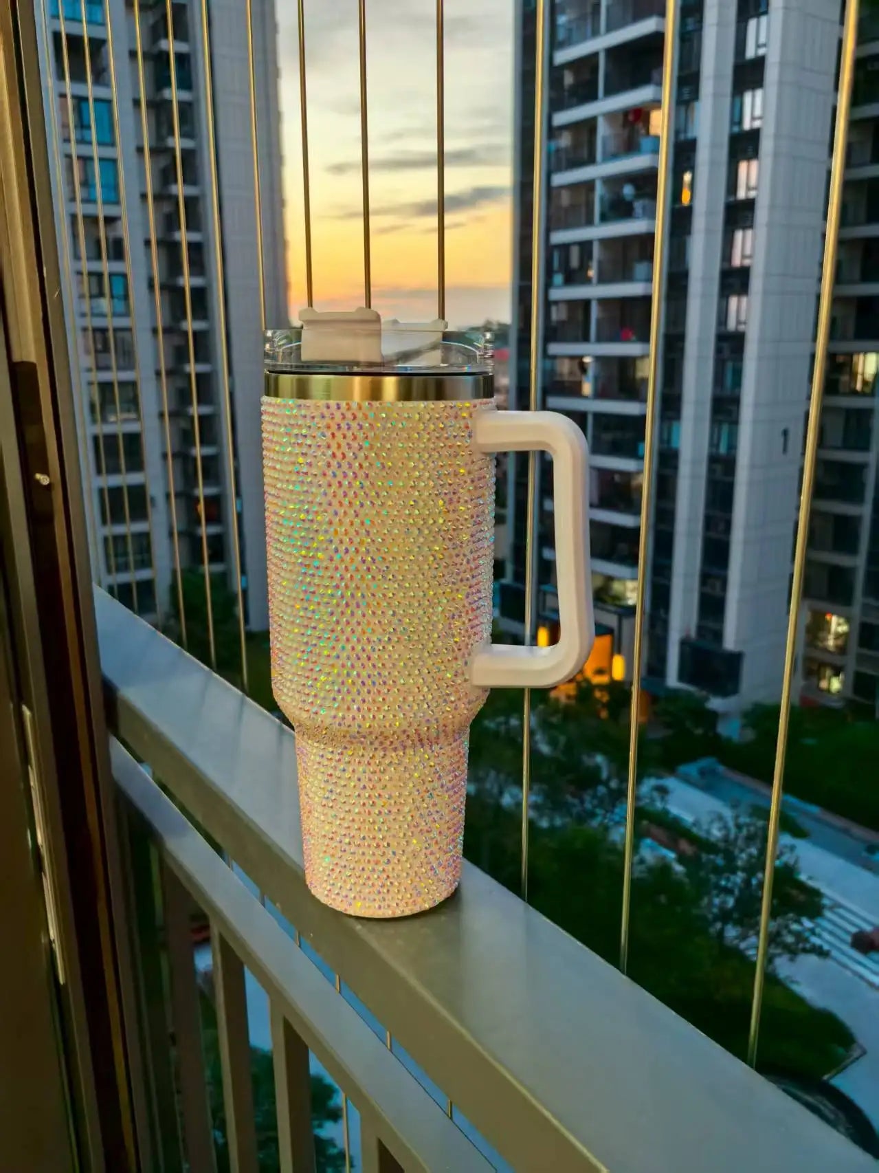 Sparkly mug on a balcony railing with cityscape in the background