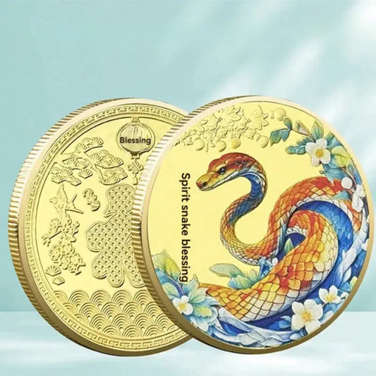 A collectible coin with a 3D relief design of a snake and floral patterns, predominantly in gold and silver colors.