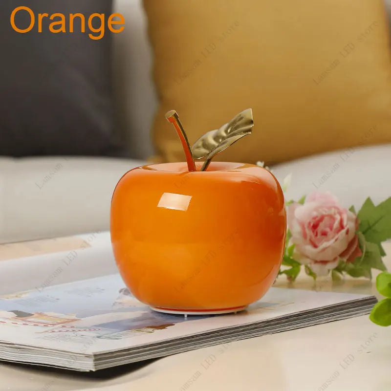 Orange decorative apple on a magazine with a blurred background