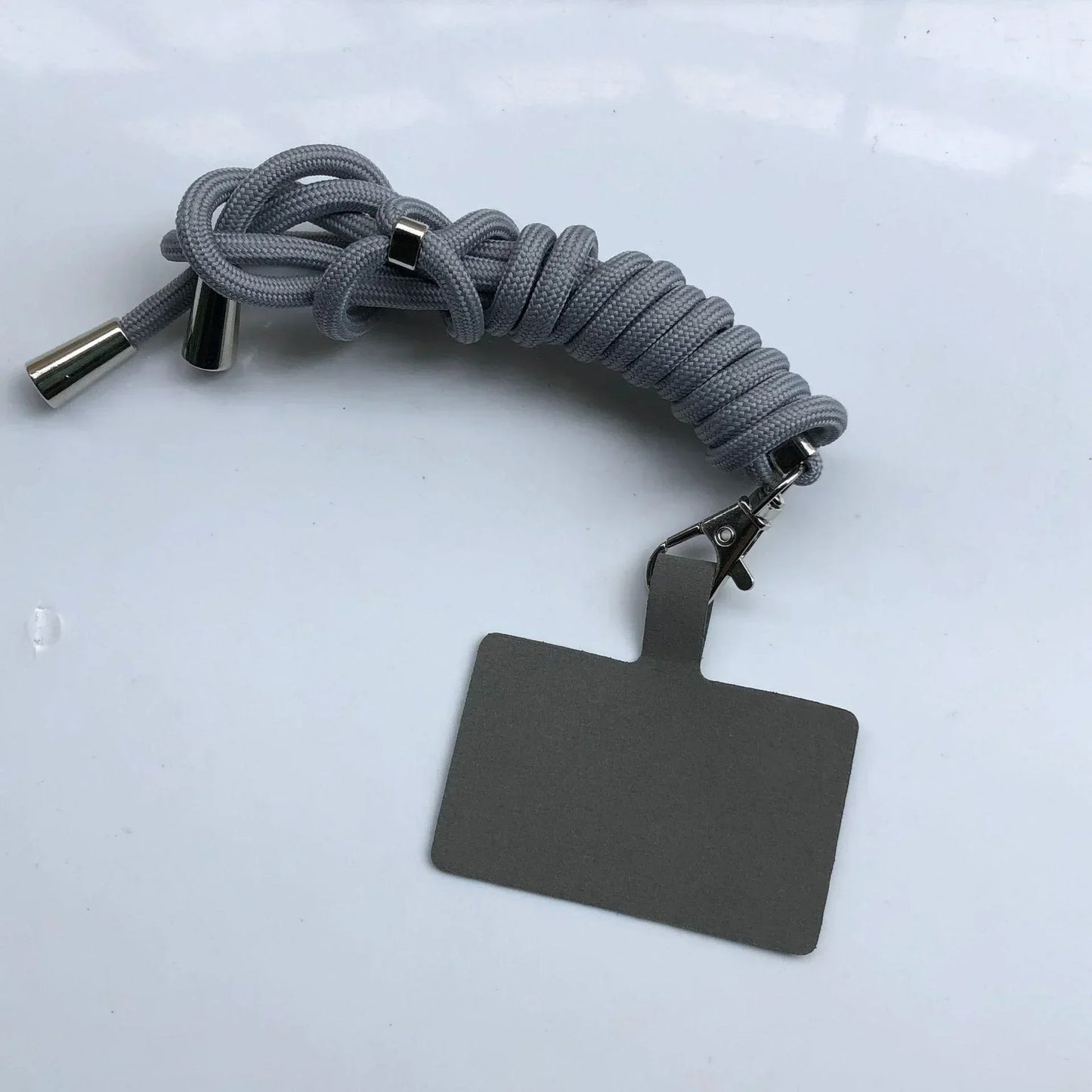 Gray braided lanyard with a metal clip and blank gray tag on a white background