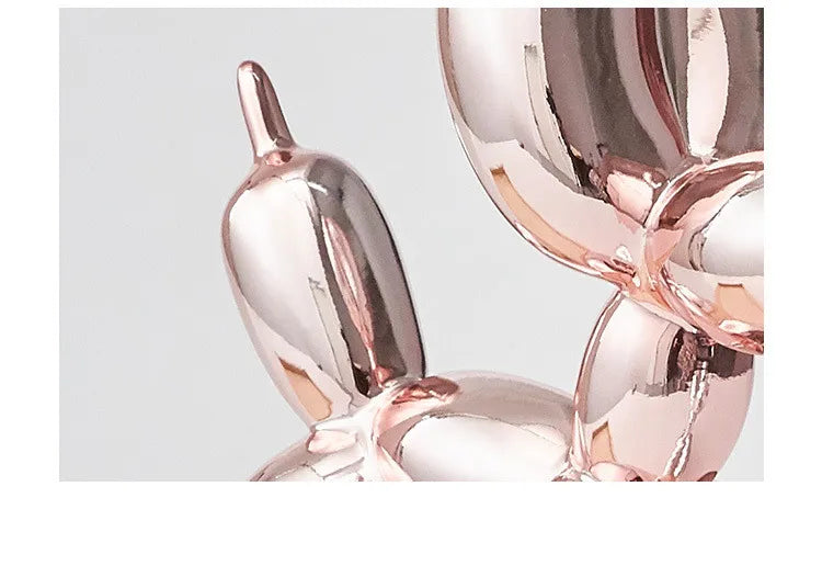 Rose gold balloon dog sculpture on a light gray background