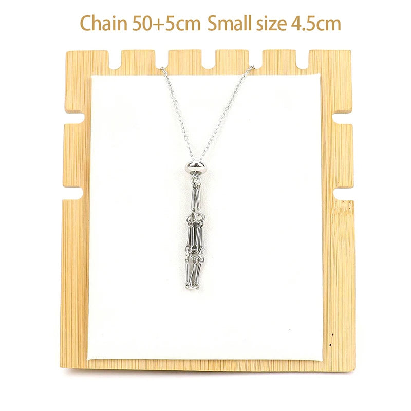 Necklace with a small pendant on a wooden display stand with text indicating chain length and pendant size.