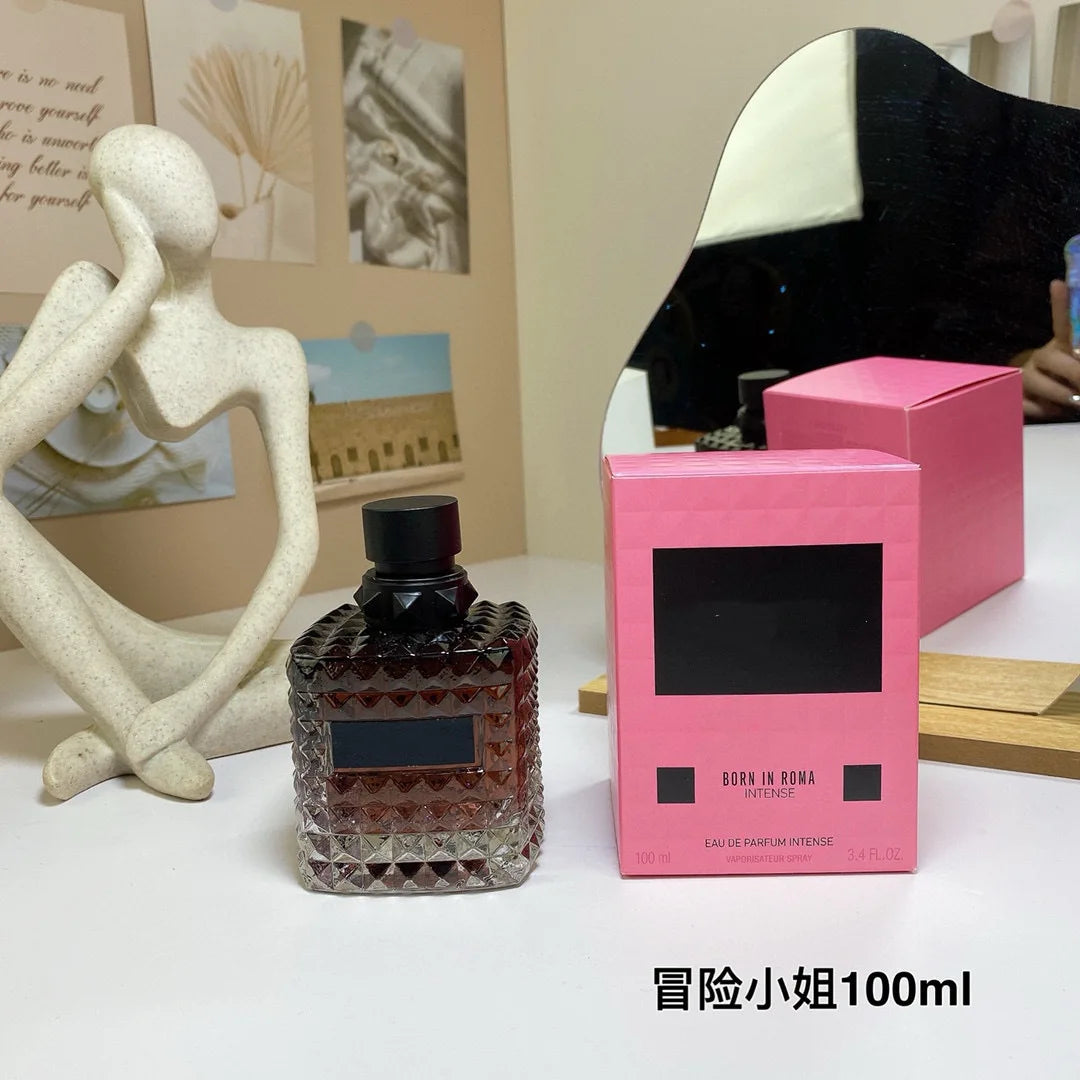 Valentino Perfume bottle and pink box on a table with decorative elements in the background