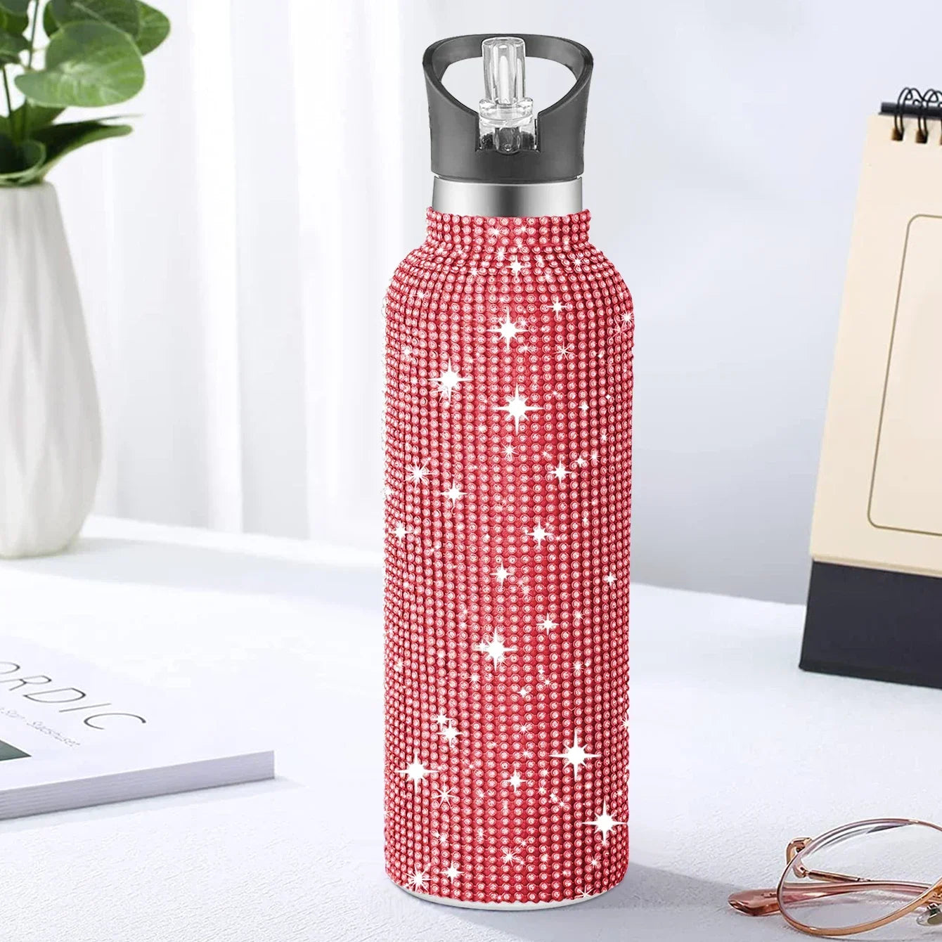 Red water bottle with star pattern on a white surface