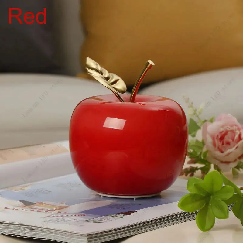 Decorative red apple with a gold stem on a magazine