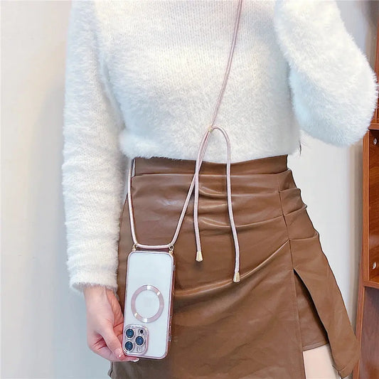 Person wearing a white fluffy sweater and brown leather skirt holding a phone with a pink case.