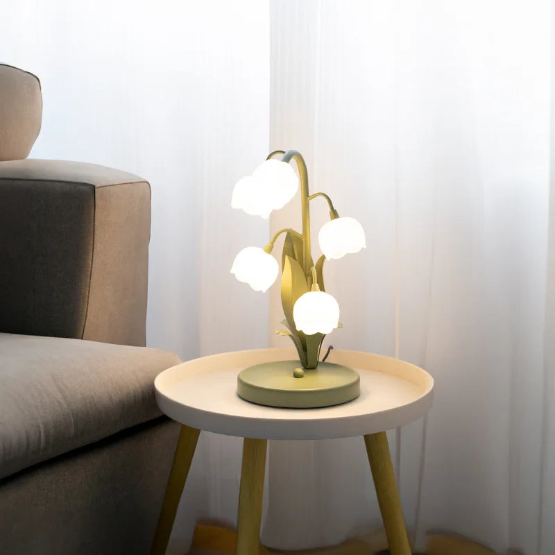 Modern table lamp on a small round table next to a sofa in a living room setting.