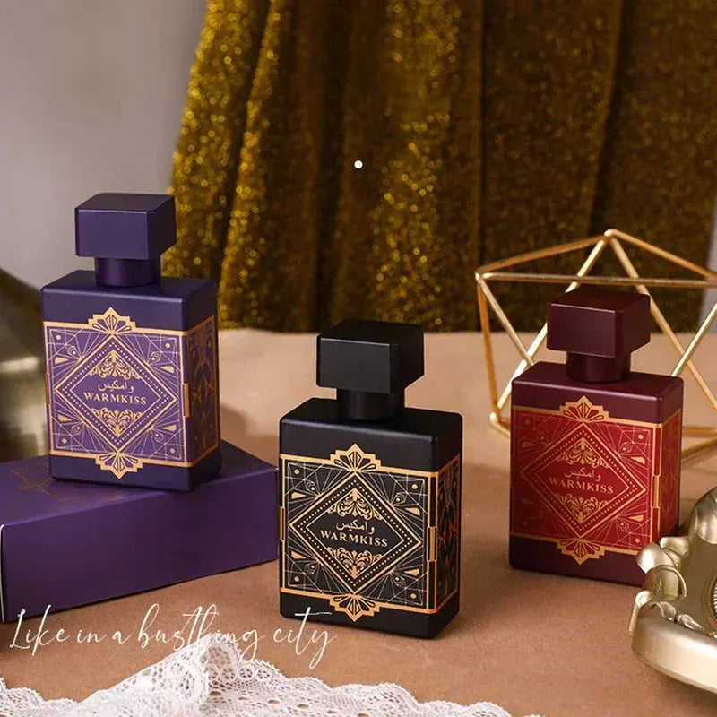 Three perfume bottles with decorative labels on a textured surface.
