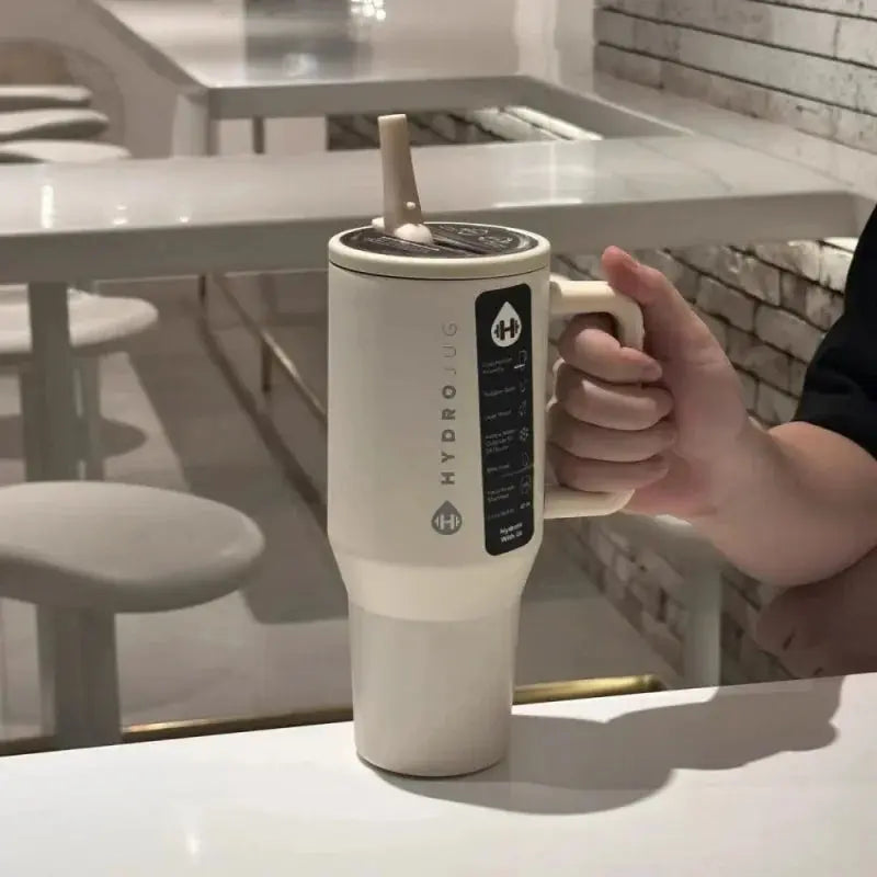 Beige HydroJug Gobelet 40OZ Voyageur Thermos with flip straw in use, highlighting its ergonomic and user-friendly design.