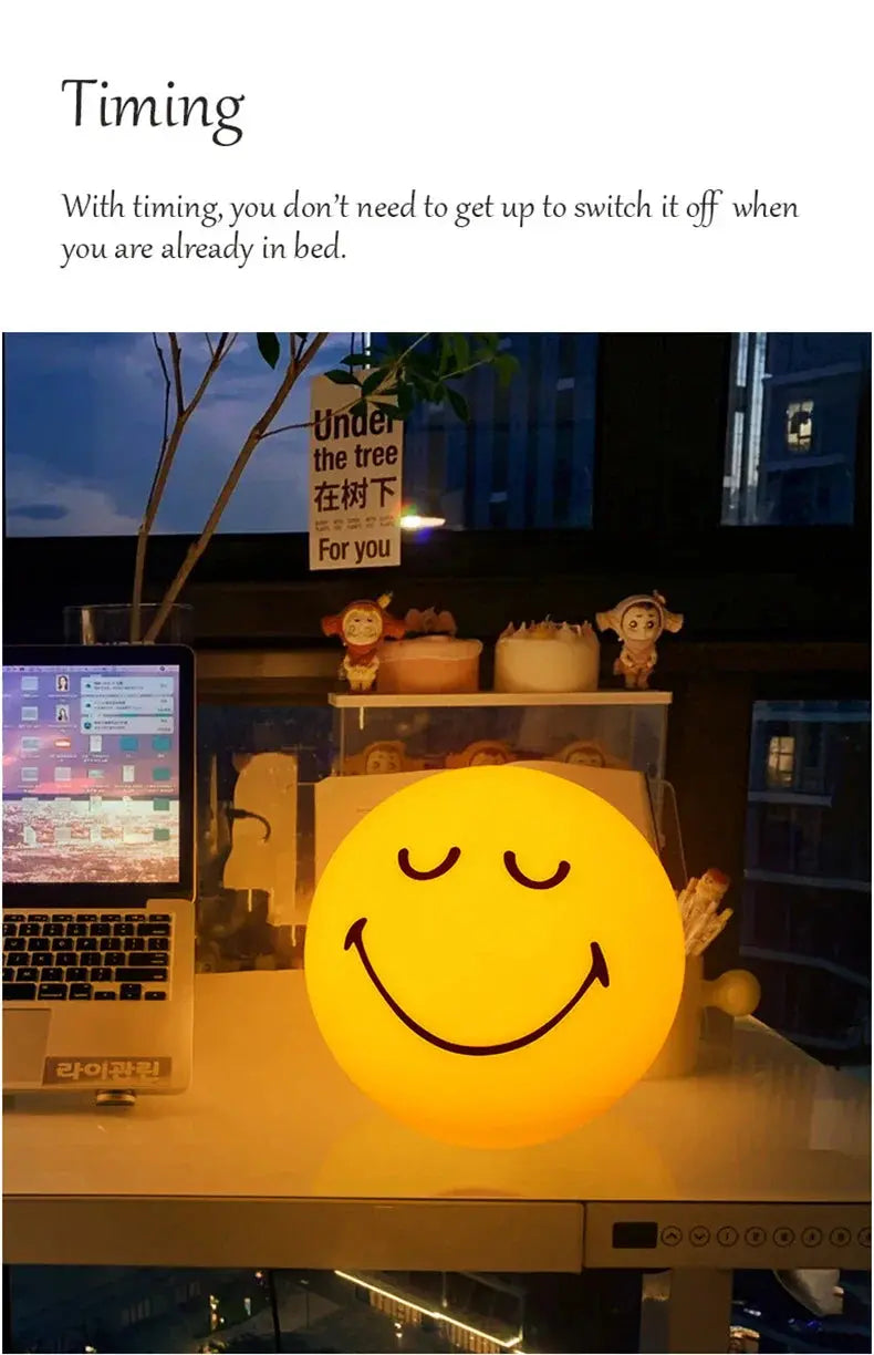 Smiley face night light on a desk with computer and decor in the background