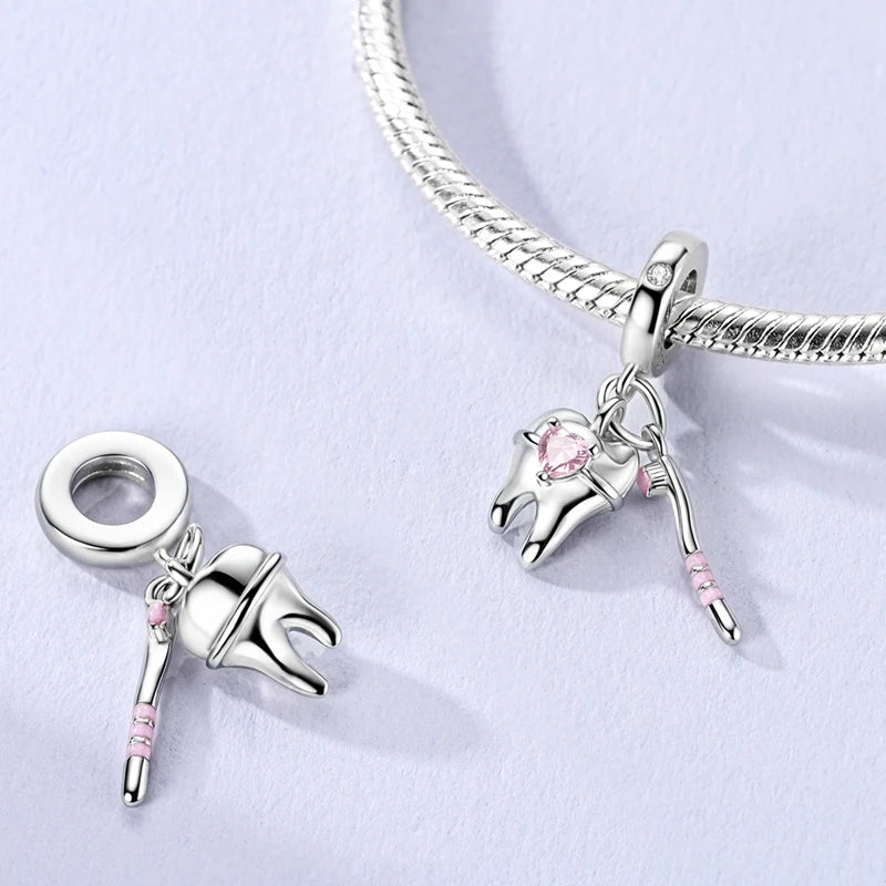 Silver bracelet with two charms on a light gray background. pandora style