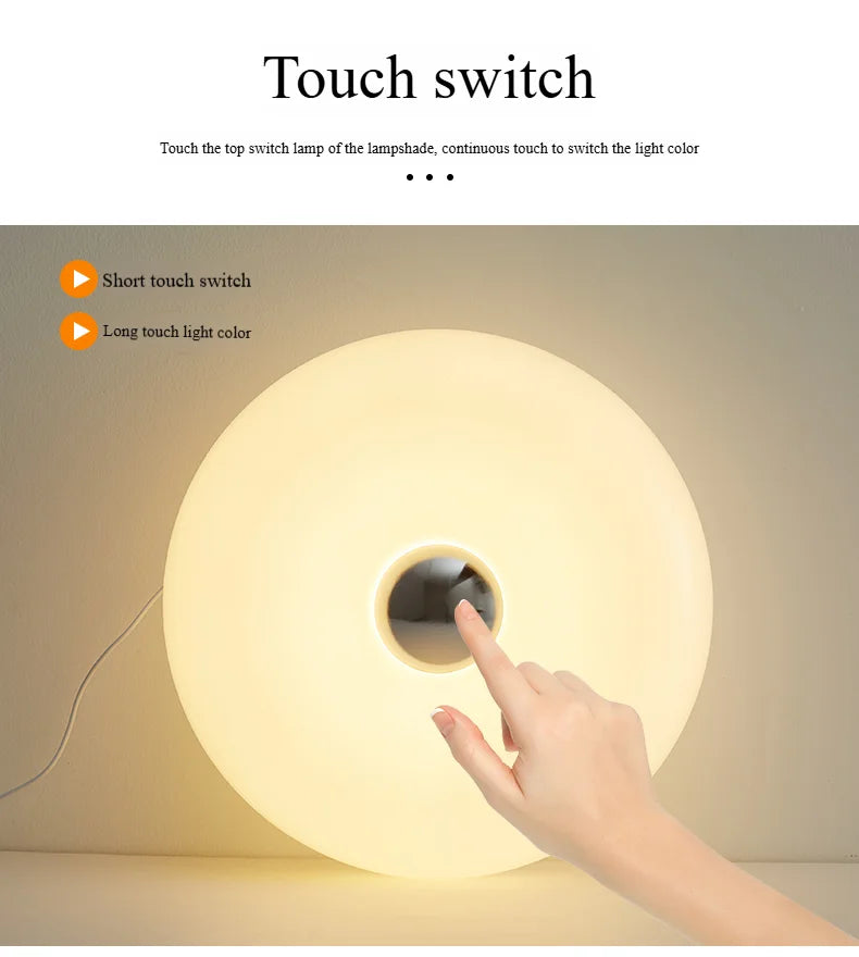Touch switch on a lampshade with a hand demonstrating the operation.