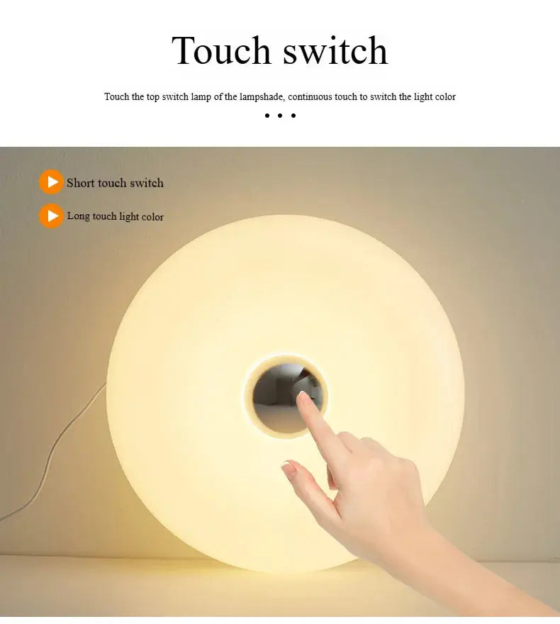 Touch switch on a lampshade with a hand demonstrating the operation.