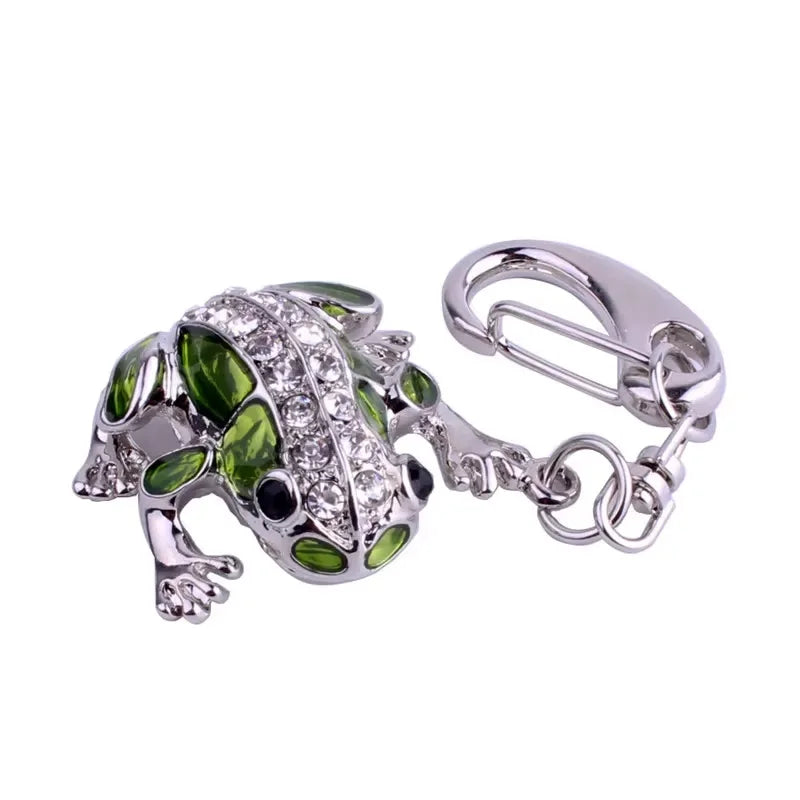 Green frog-shaped keychain with a silver clasp on a white background
