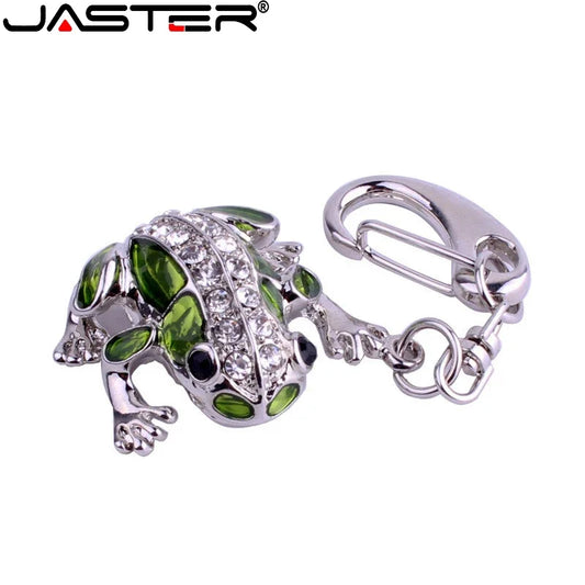 Frog-shaped keychain with green details and a silver clip on a white background, featuring the brand 'JASTER'.
