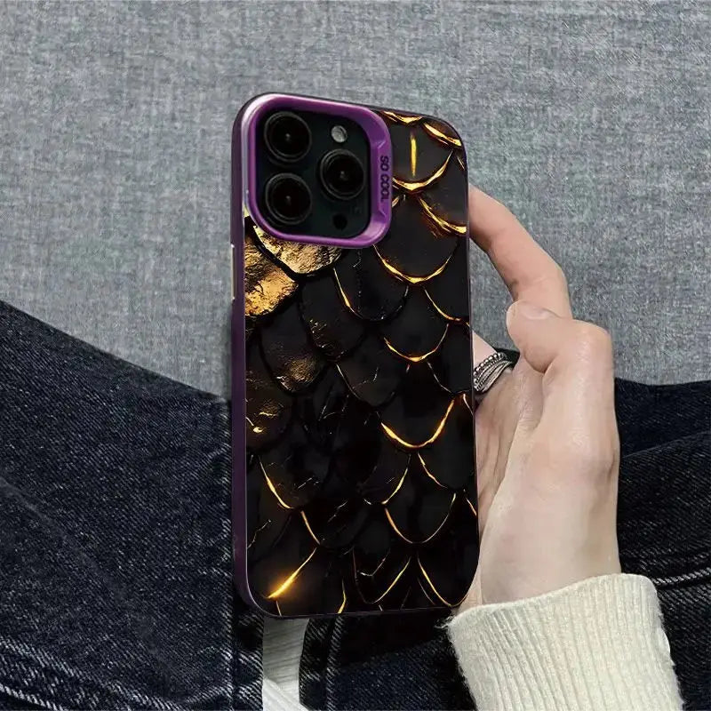 Phone case with gold dragon scale design held by a person against a gray background