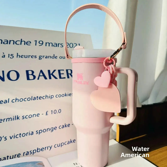 stnley Pink water bottle with heart-shaped keychain on a table with a menu in the background