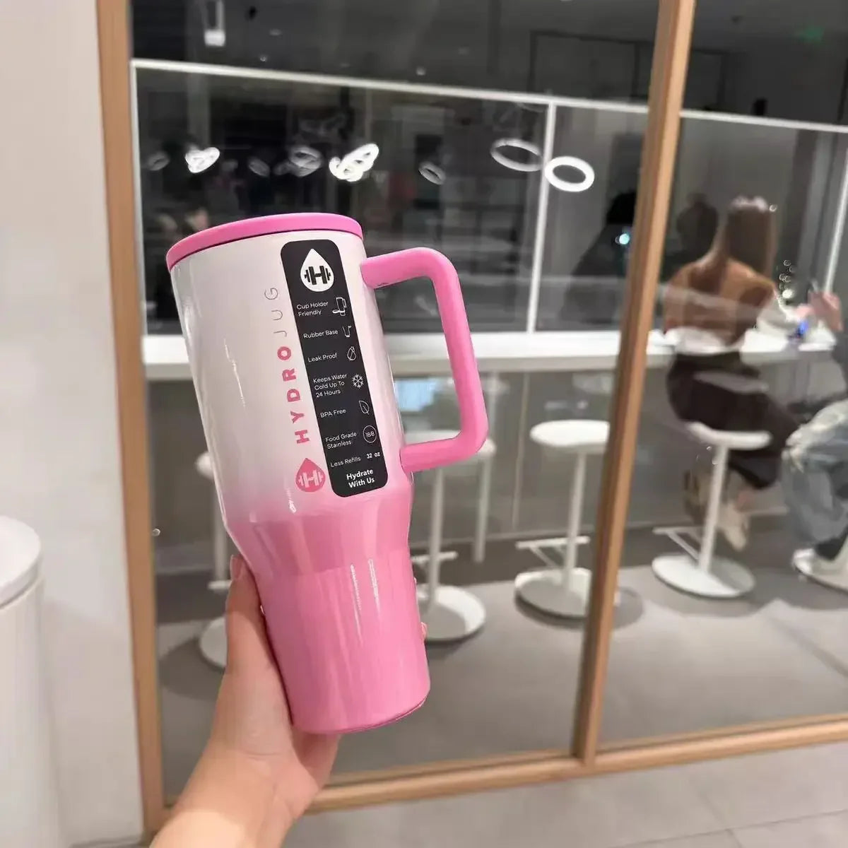 Pink and white HydroJug Gobelet 40OZ Voyageur Thermos with product label, perfect for stylish and leakproof hydration.
