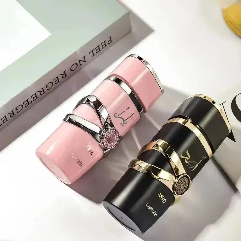 Two lipsticks, one pink and one black with gold accents, on a white surface.