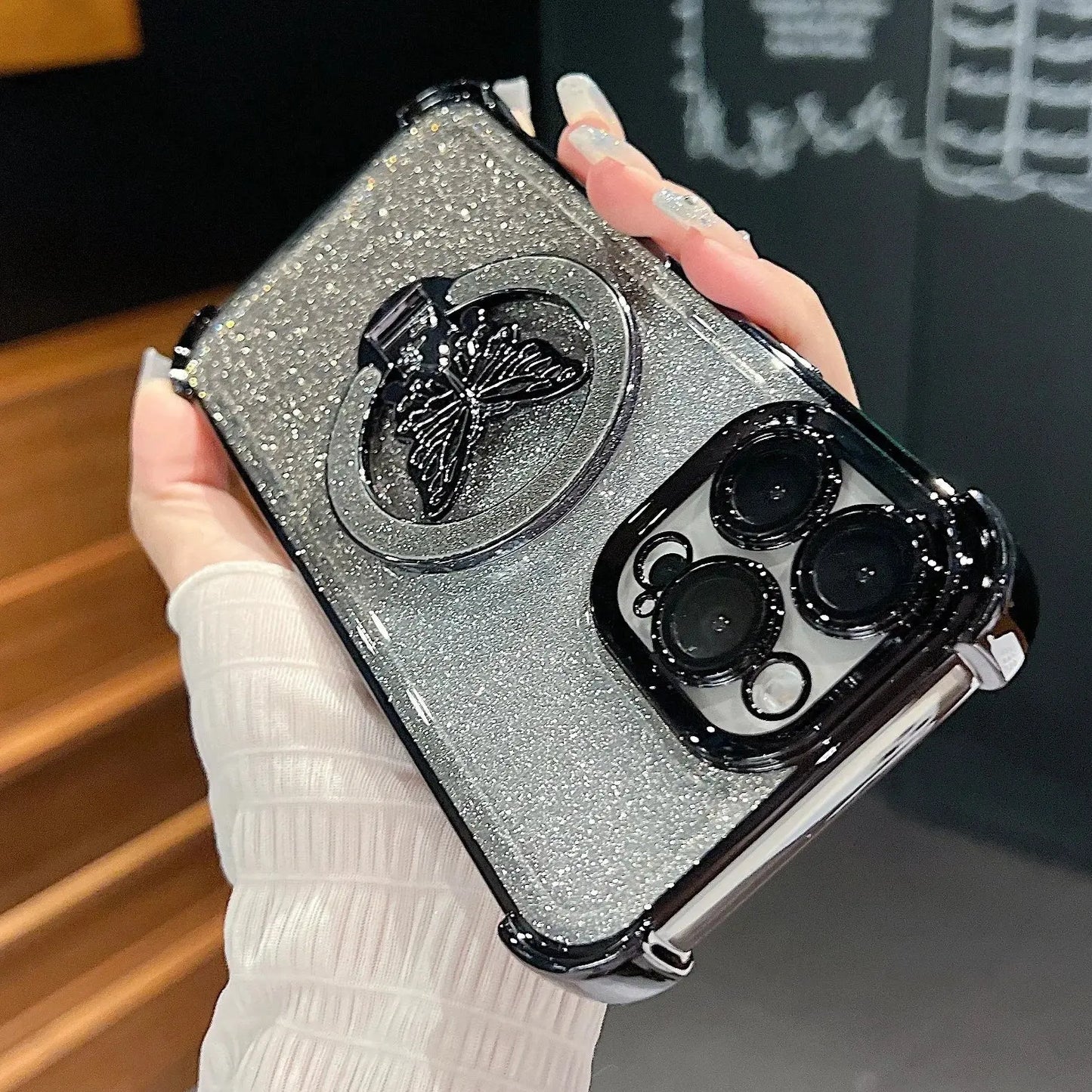 Phone case with butterfly design held by a hand