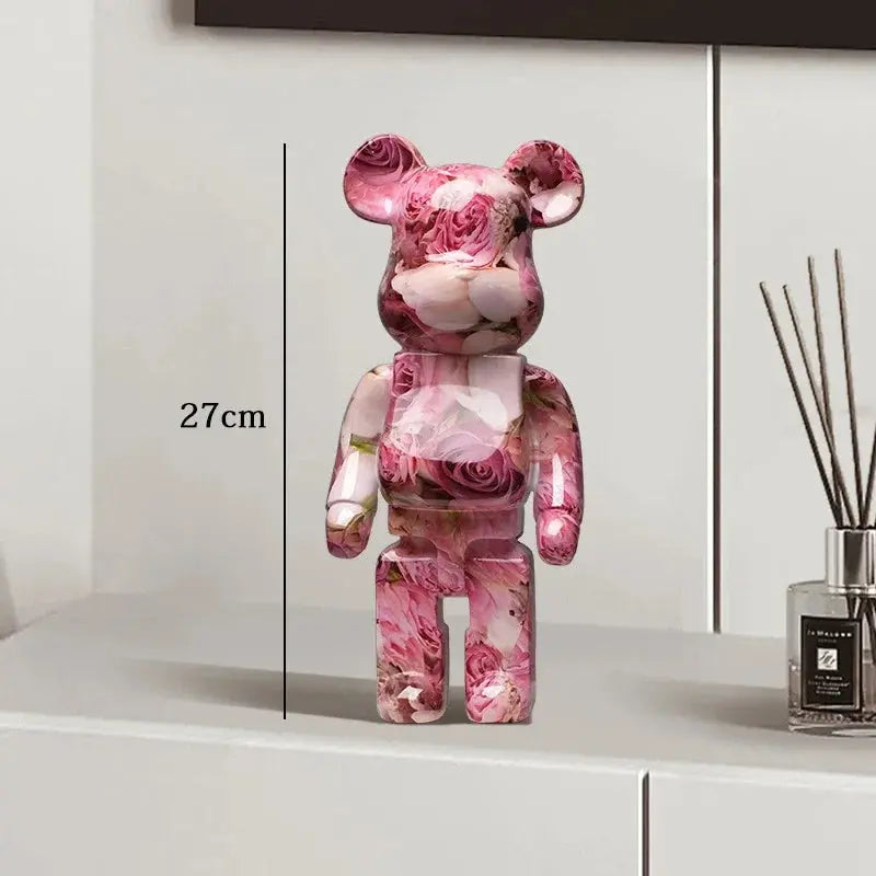 Pink floral-patterned bear figure on a white surface with a diffuser in the background be@rbrick collectable