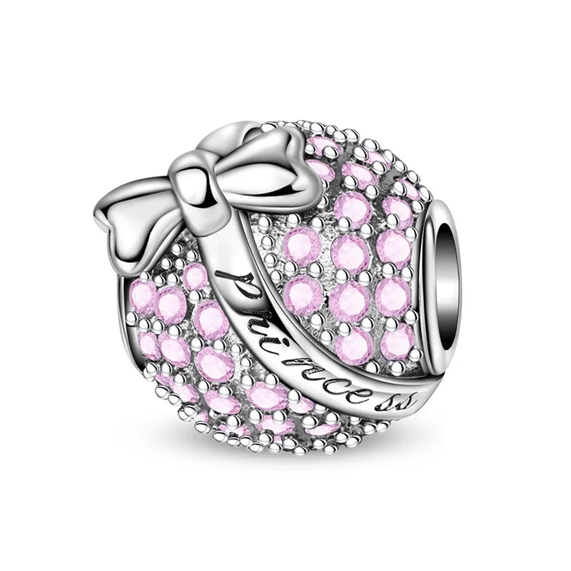 Silver charm with pink stones and a bow on a white background